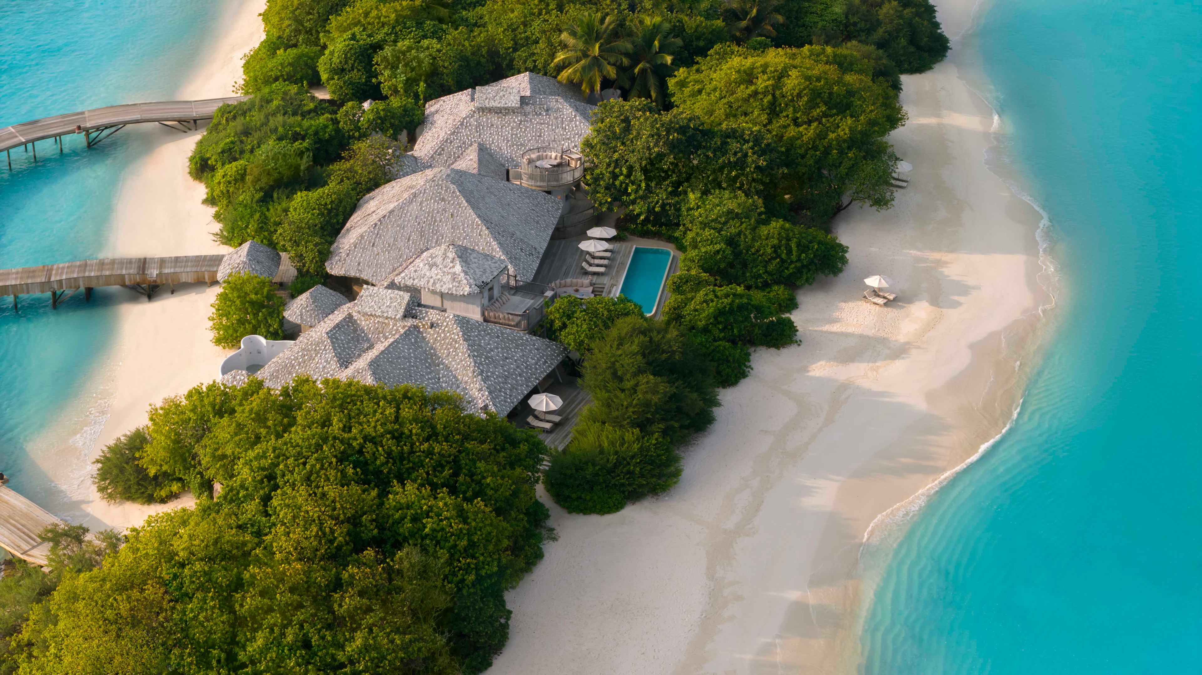 Aerial view of Soneva Secret ultra-luxury Maldives private island resort surrounded by turquoise lagoon and white sand beach Indian Ocean